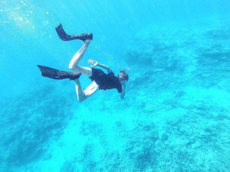 A student dives into turquoise reef waters, discovering inner resilience and a profound connection to our living Earth.