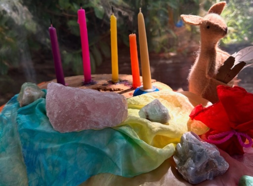 Vibrant candles and handcrafted treasures form an earth-centred altar, honouring the seasonal rhythms and sacred spirit of playgroup.
