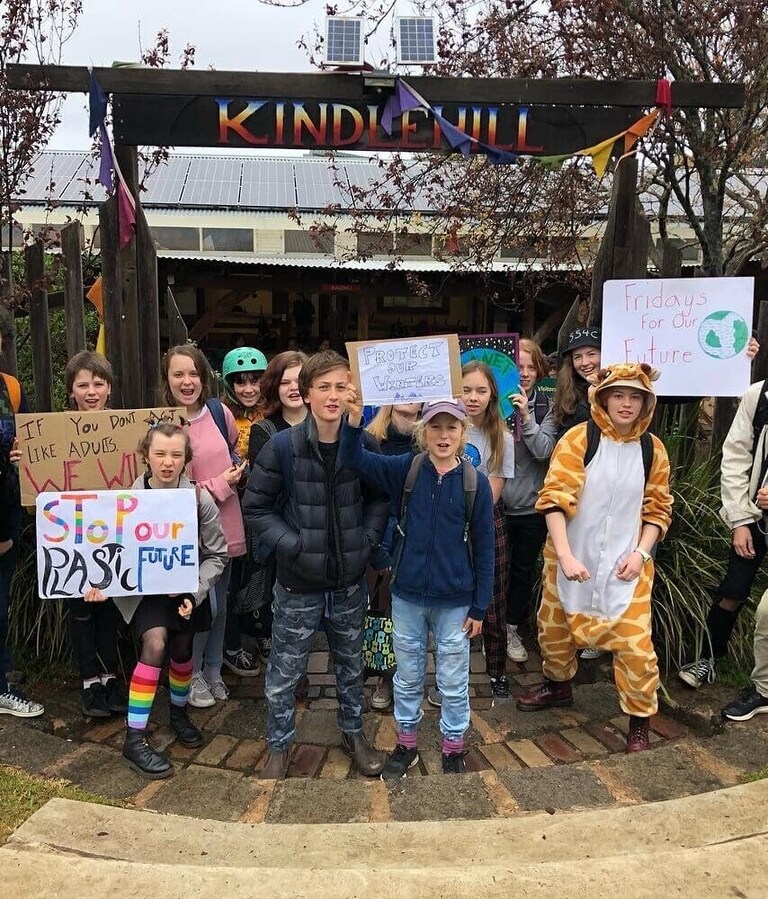 Empowered Kindlehill students take meaningful social action, standing united beneath their school sign to advocate for the Earth.
