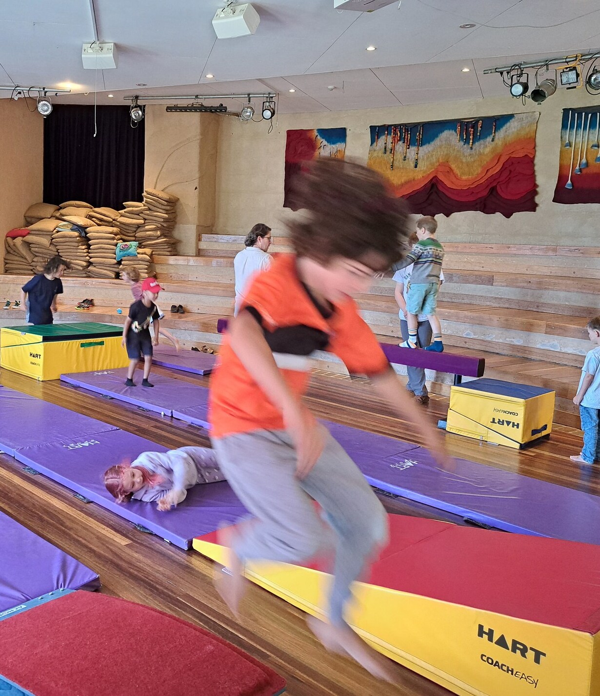 Kindlehill students cultivate physical resilience and joy through energetic movement and cooperative play within the communal hall.