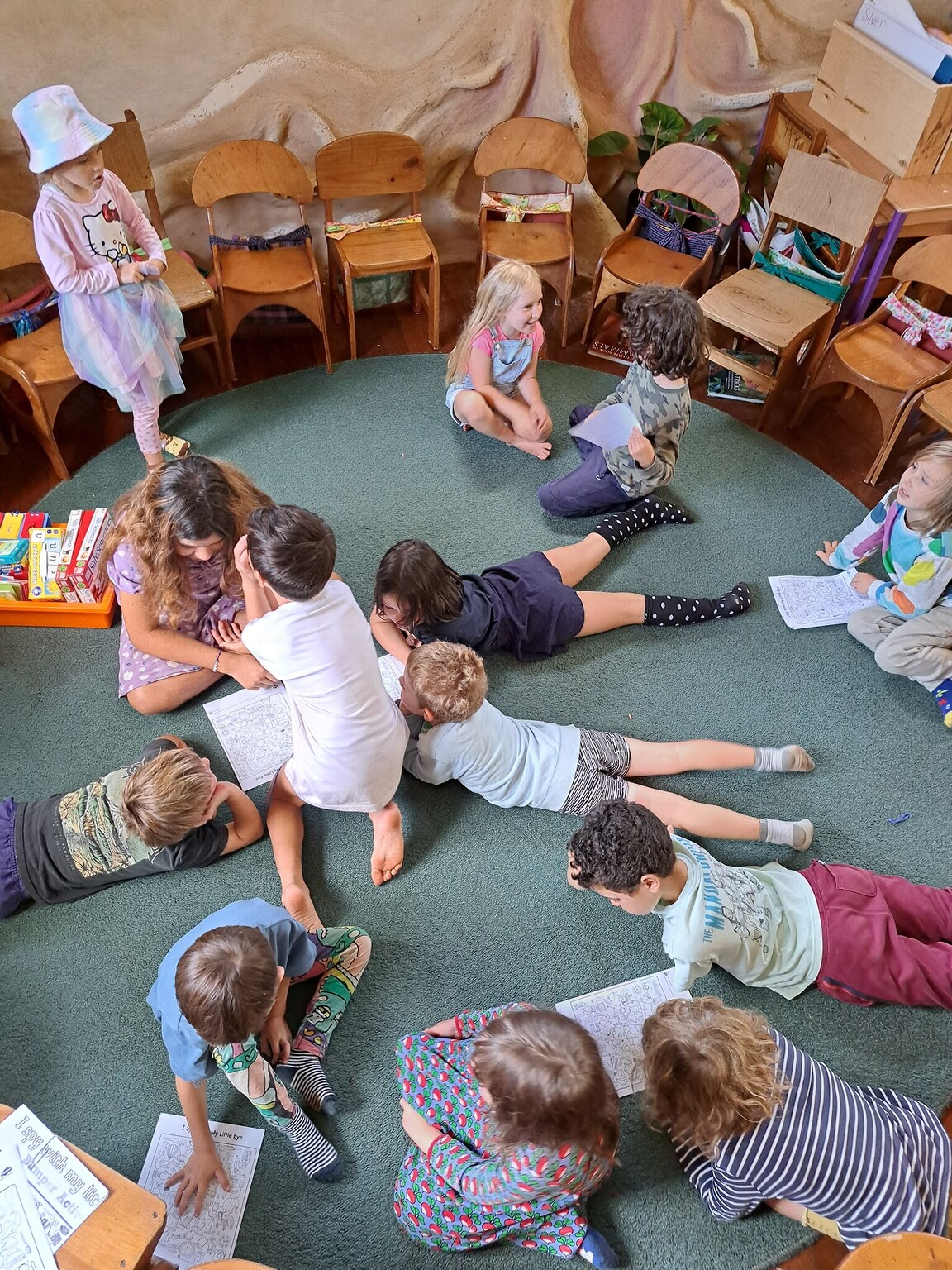 Children cluster on the classroom rug, fostering a spirit of community and shared purpose through cooperative learning.