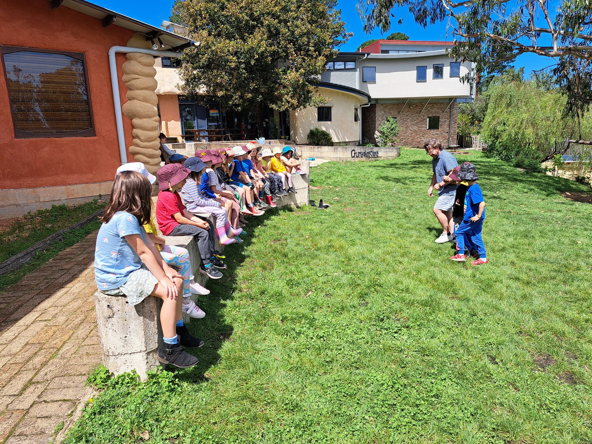 Kindlehill students gather on the grass, cultivating community spirit and connection to land through outdoor storytelling.