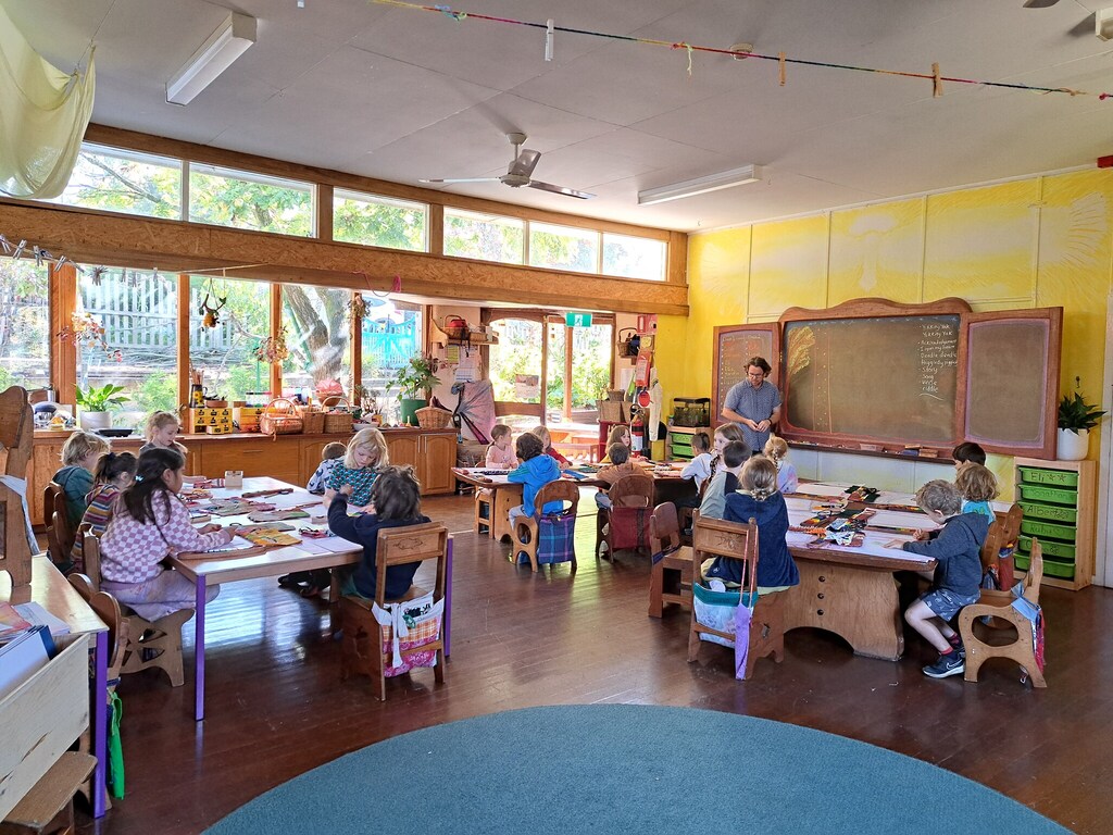 Children nurture head, heart, and hands through artistic expression within a warm, sun-drenched classroom environment at Kindlehill.