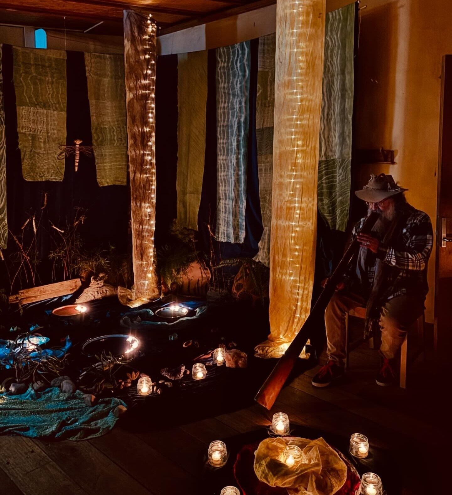 Didgeridoo song resonates in a sacred candlelit sanctuary, honouring Country and awakening a deep sense of the sacred.