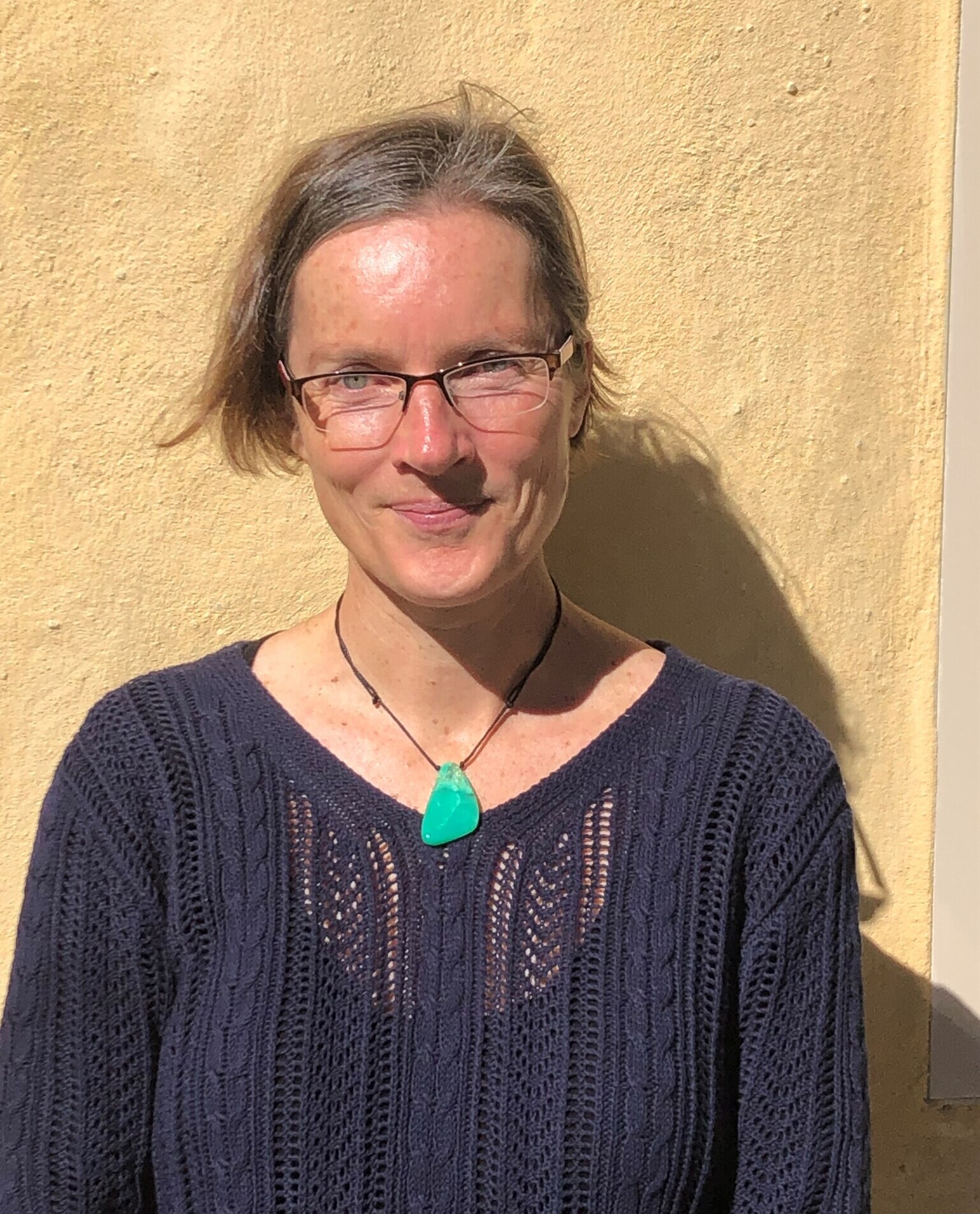 A Kindlehill educator wearing a green pendant embodies our schools grounded spirit and deep connection to nature.