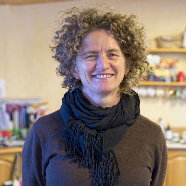 A smiling community member radiates warmth, embodying Kindlehills focus on deep human connection and cultivating whole humans.