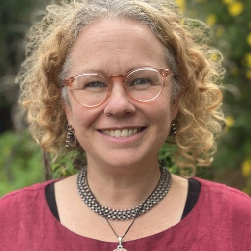 A smiling educator embodying Kindlehills warm community spirit and a deep, nurturing connection to the living world.