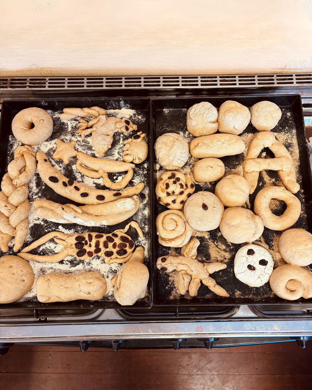Hand-sculpted dough shapes honour individual imagination within the shared rhythm of community work and collective nourishment.