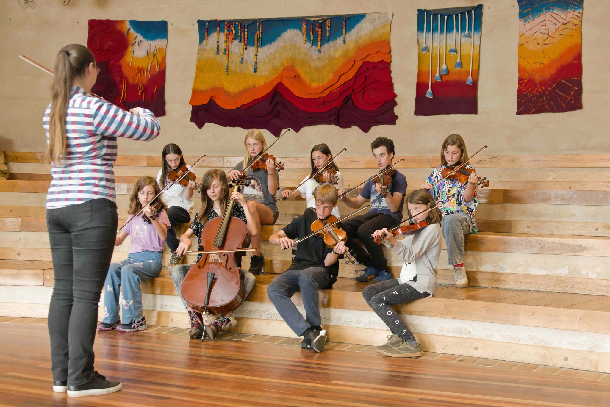 Students harmonise with string instruments, cultivating creative expression and a shared sense of belonging within the Kindlehill village.