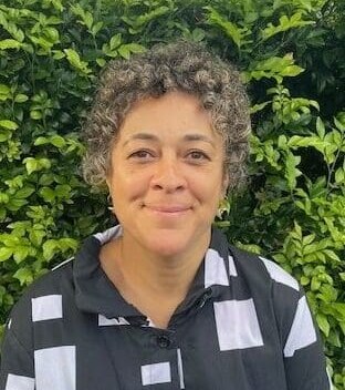 A smiling woman embodies the Kindlehill spirit of belonging and a deep, earth-centred connection to nature.