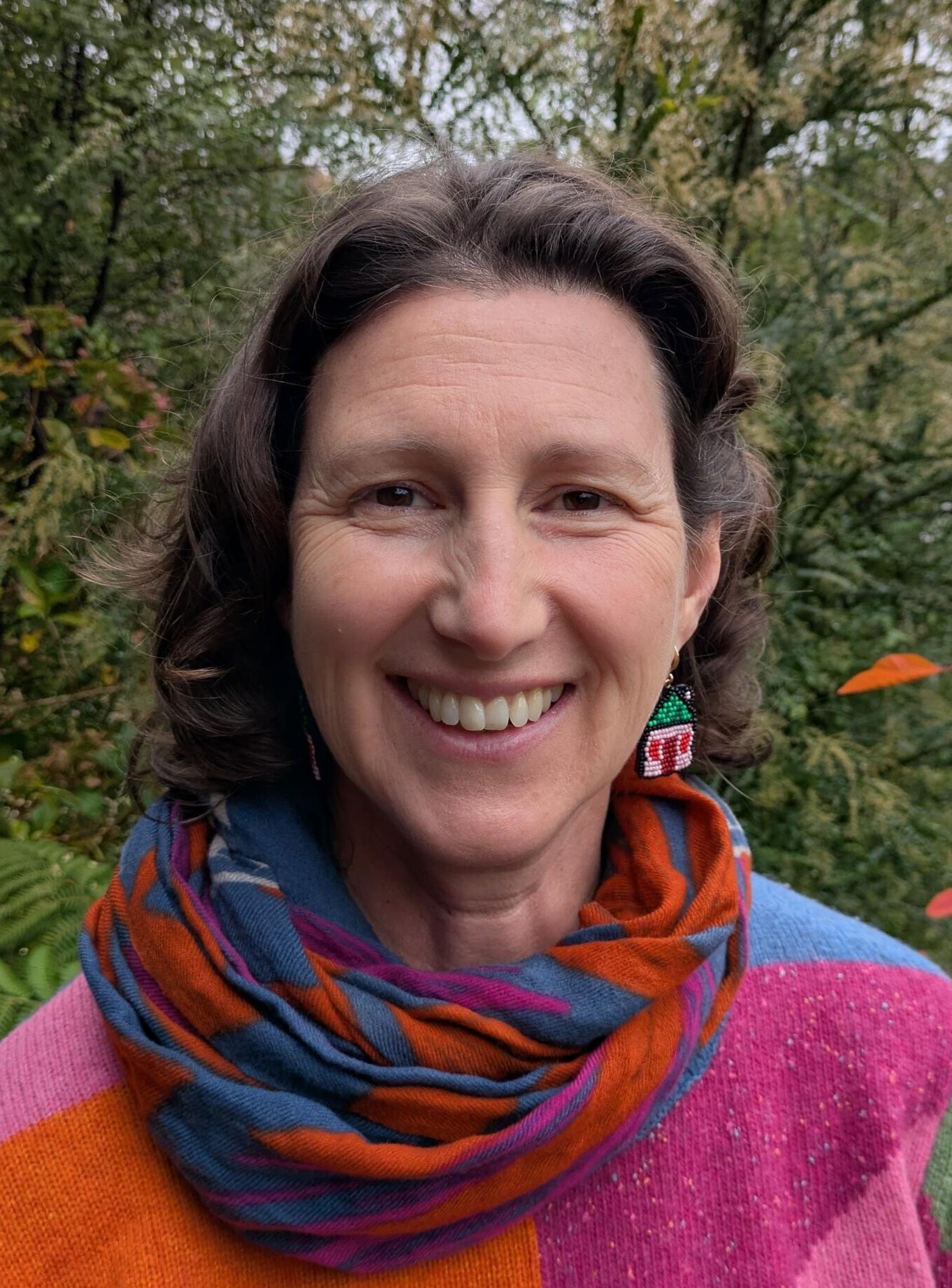 Smiling Kindlehill educator amongst Blue Mountains greenery, embodying community warmth and a deep connection to nature and Country.