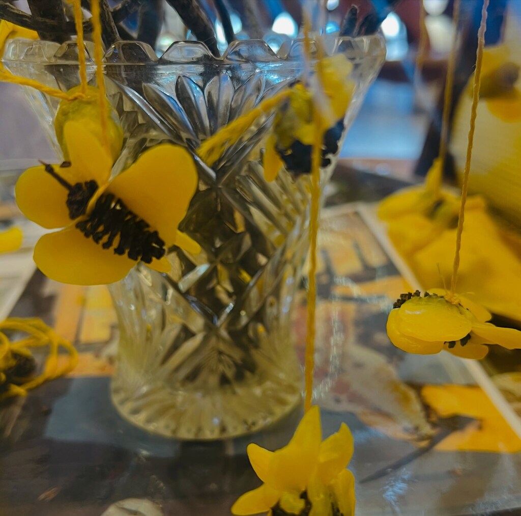 Handcrafted yellow bees hang from branches, symbolising the cooperative spirit and warmth of the Kindlehill hive.